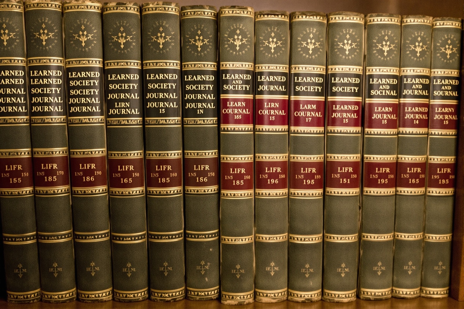 Rangée de volumes reliés d'annales savantes sur une étagère